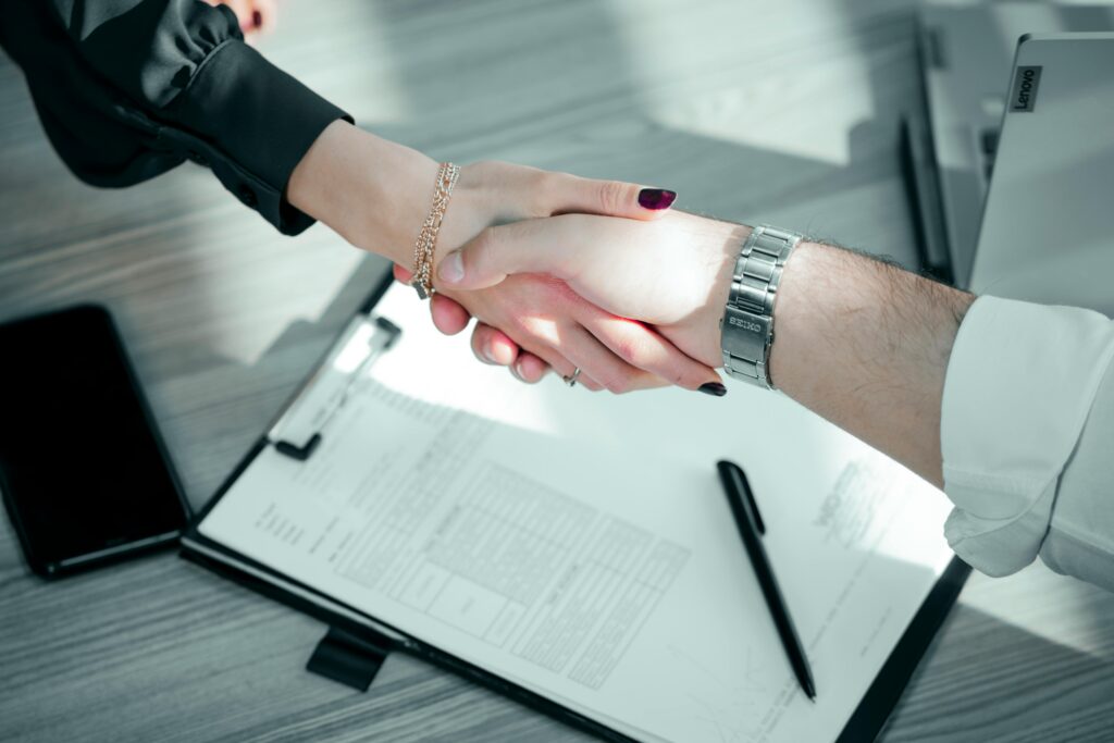 A business professional shaking hands with clients after closing a deal.